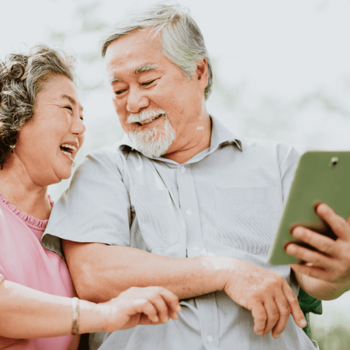 Seniors laughing together asking "Can I Get A Reverse Mortgage?"