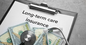 paper on clipboard that says long-term care insurance and a pile of 100 dollar bills to show how expensive it it